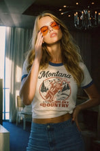 Load image into Gallery viewer, Woman wearing a 'Montana Big Sky Country' t-shirt in an indoor setting.