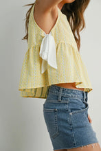 Load image into Gallery viewer, Woman wearing a yellow floral top with a white bow and blue denim shorts on a plain background