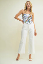 Load image into Gallery viewer, Woman wearing a floral strapless top and white pants on a plain background