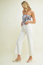 Load image into Gallery viewer, Woman wearing a floral strapless top and white pants on a plain background