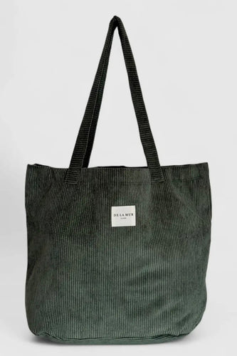 Green corduroy tote bag with a visible brand label on a light gray background