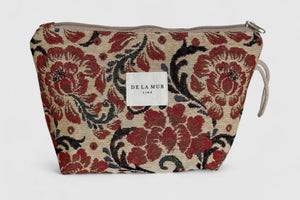 Floral patterned pouch with 'De La Mur' label on a light gray background