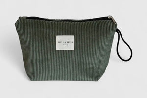 Green ribbed clutch bag with a visible brand label on a light gray background