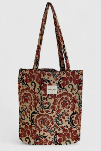 Floral patterned tote bag with a visible brand label on a light gray background