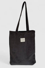 Load image into Gallery viewer, Black corduroy tote bag with a visible brand label on a light gray background