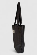 Load image into Gallery viewer, Black tote bag with a visible brand label on a light gray background