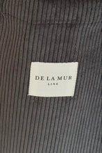 Load image into Gallery viewer, Close-up of dark gray corduroy fabric with a &#39;De La Mur&#39; label.