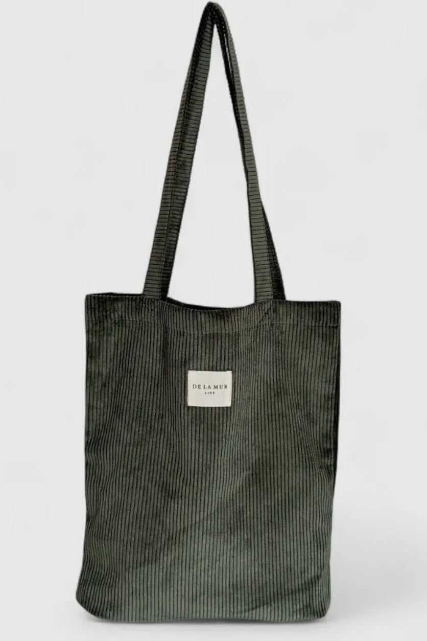 Green corduroy tote bag with a visible brand label on a white background
