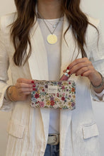 Load image into Gallery viewer, Person holding a floral clutch with a plain background