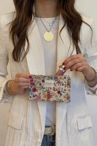 Person holding a floral clutch with a plain background