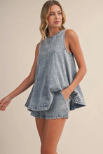 Load image into Gallery viewer, Woman wearing a light blue denim dress against a beige background