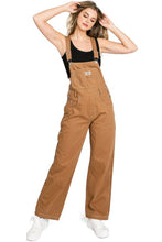 Load image into Gallery viewer, Woman wearing brown overalls on a white background