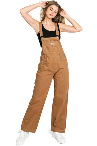 Woman wearing brown overalls on a white background