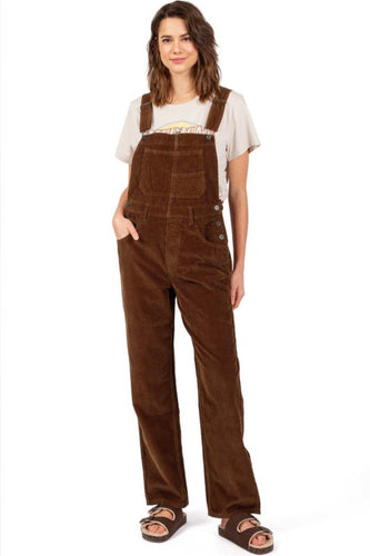 Woman wearing brown corduroy overalls on a white background