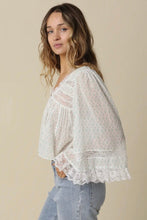 Load image into Gallery viewer, Woman wearing a white lace blouse with light blue jeans against a beige background