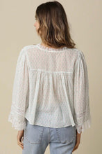 Load image into Gallery viewer, Woman wearing a light-colored blouse with lace details and jeans on a beige background