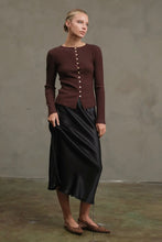 Load image into Gallery viewer, Woman wearing a brown ribbed sweater and black skirt against a plain background