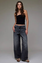 Load image into Gallery viewer, Woman wearing a black top and wide-leg jeans against a neutral background