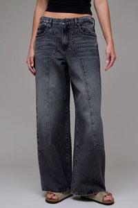 Person wearing wide-leg jeans on a plain background