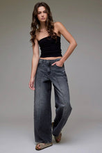 Load image into Gallery viewer, Woman wearing a black top and blue jeans against a gray background
