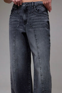 Black jeans worn by a person on a gray background