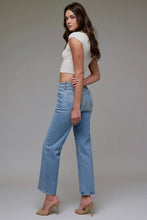Load image into Gallery viewer, Woman wearing a white top and blue jeans on a gray background
