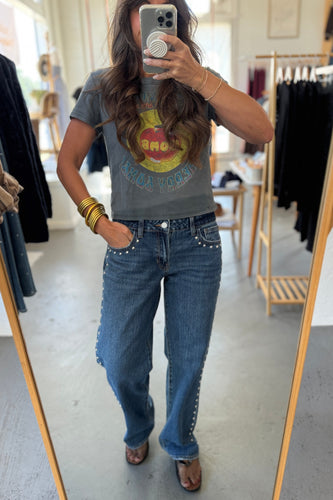 Person wearing a graphic t-shirt and jeans in a clothing store.