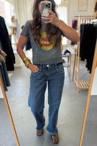 Person wearing a graphic t-shirt and jeans in a clothing store.