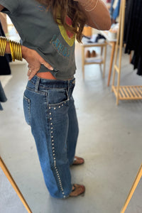 Person wearing a graphic t-shirt and blue jeans in a store setting