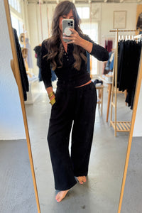 Person wearing a black outfit in a clothing store