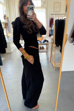 Load image into Gallery viewer, Person wearing a black outfit in a clothing store