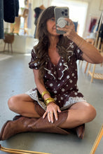 Load image into Gallery viewer, Woman taking a mirror selfie wearing a patterned dress and brown boots in a store.