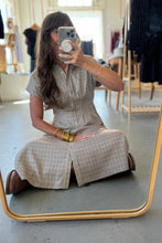 Load image into Gallery viewer, Woman taking a mirror selfie wearing a checkered dress in a clothing store.