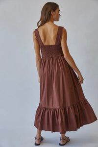 Woman wearing a brown dress with a plain background