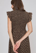 Load image into Gallery viewer, A woman shown from the back wearing a dark brown smocked dress with a small beige floral print and ruffled cap sleeves, set against a plain light gray studio background.