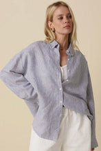 Load image into Gallery viewer, Woman wearing a blue striped shirt over a white top with a beige background