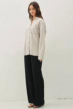 Load image into Gallery viewer, Woman wearing a beige shirt and black pants on a white background