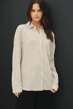 Load image into Gallery viewer, Woman wearing a beige button-up shirt against a black background