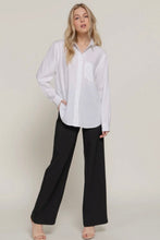 Load image into Gallery viewer, Woman wearing a white shirt and black pants on a plain background