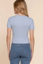 Load image into Gallery viewer, Person wearing a light blue t-shirt and jeans on a beige background