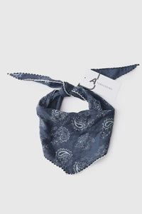 Blue bandana with white patterns on a light gray background