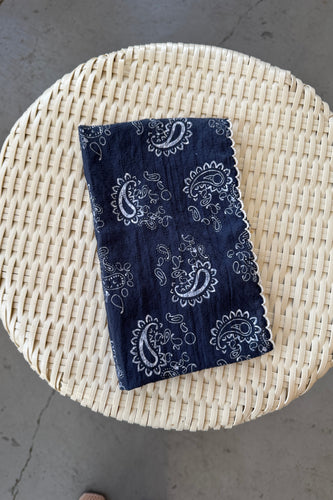 Blue bandana with white patterns on a woven surface