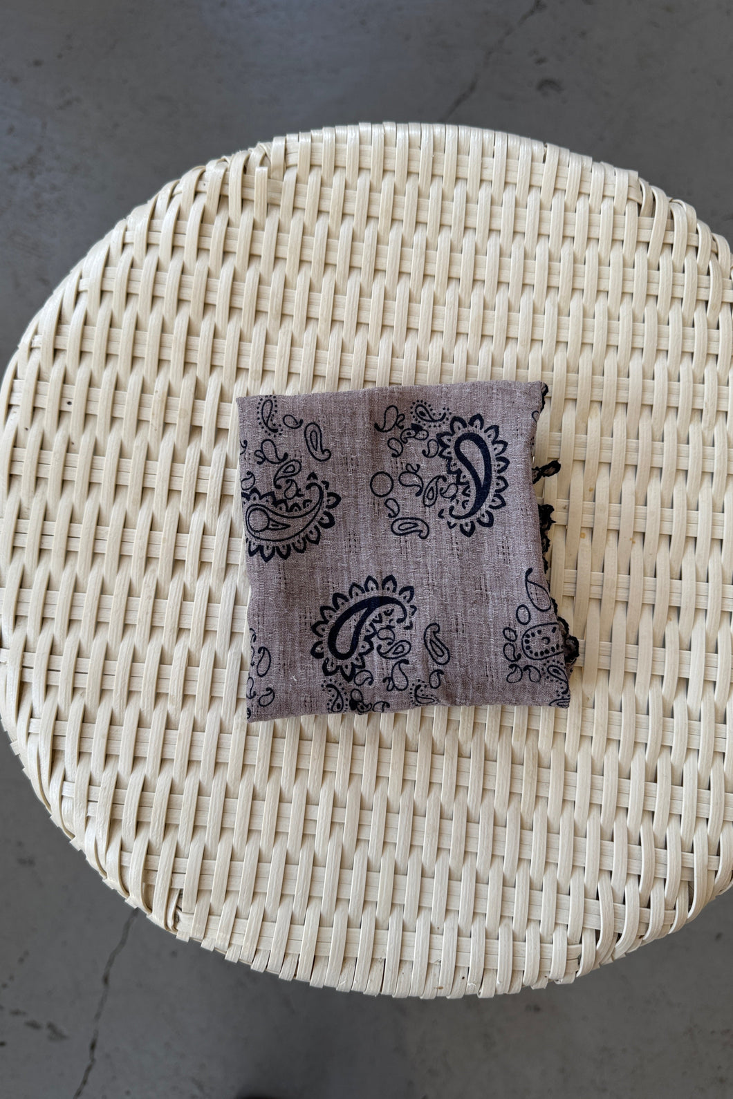 Woven basket with a patterned pouch on a gray surface