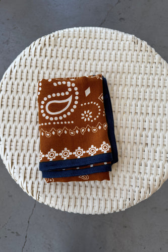 Folded fabric with brown and blue patterns on a woven mat