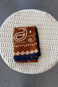 Folded fabric with brown and blue patterns on a woven mat
