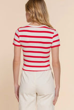 Load image into Gallery viewer, Person wearing a red and white striped shirt against a beige background
