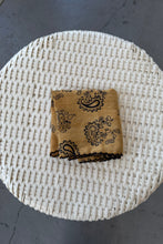 Load image into Gallery viewer, Burlap bag with black patterns on a woven mat