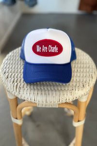 Trucker hat with 'We Are Charlie' on a wicker stool