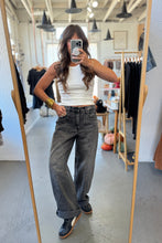 Load image into Gallery viewer, Person taking a mirror selfie wearing a white tank top and gray jeans in a clothing store.
