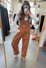 Load image into Gallery viewer, Person wearing brown overalls taking a mirror selfie in a clothing store.